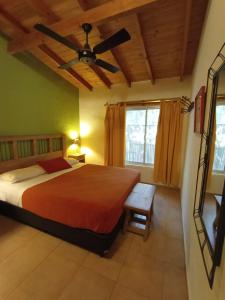 a bedroom with a bed and a ceiling fan at Manantial Hostería & Cabañas in Nono
