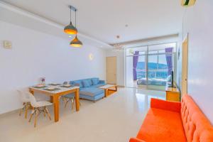 a living room with a table and a blue couch at Căn hộ Oasky 3 phòng ngủ sát quảng trường Vũng Tàu in Vung Tau