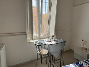 a table with two chairs in a room with a window at B&B Il sogno in Cagliari