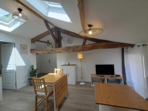 a living room with a wooden table and a tv at Le Cosy, Calme, parking, centre Gémozac in Gémozac