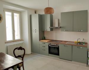 a kitchen with green cabinets and a table and a window at Il Punto Fermo in Fermo