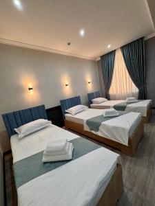 a hotel room with three beds in it at Mehran Hostel in Andizhan +24 photos