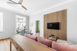 a living room with a couch and a tv on a wall at Mamalipa Apartments in Vienna