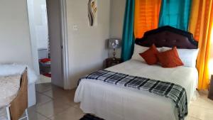 蒙特哥贝Penthouse villa的卧室里有一张带橙色和蓝色窗帘的床