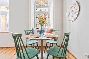 a dining room table with chairs and a vase of flowers at Mamalipa Apartments in Vienna +14 photos
