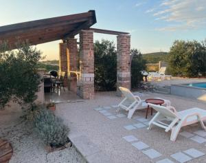 a patio with chairs and a table and a pool at Apartma Aja in Debeljak