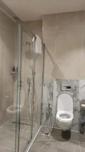 a bathroom with a toilet and a glass shower at Seabreeze Park Residence 2 in Nardaran