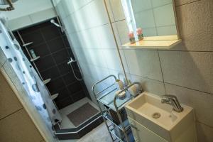 a bathroom with a sink and a shower with a mirror at West Wall Apartment in Split
