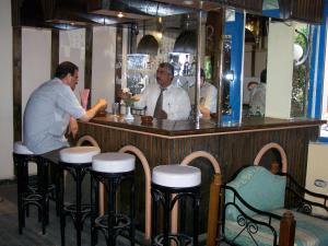 twee mannen aan een bar in een restaurant bij Eiffel Hotel Hurghada in Hurghada