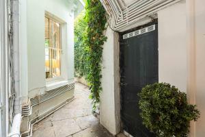 a black garage door with ivy on the side of a building at NEW Sleek and Stunning 1 Bedroom Flat Hampstead in London +22 photos