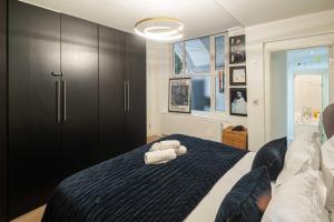 a bedroom with a bed with two towels on it at NEW Sleek and Stunning 1 Bedroom Flat Hampstead in London