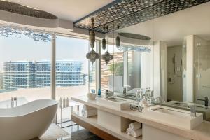 a bathroom with two sinks and a tub and a large window at Marriott Marquis Dubai Creek in Dubai