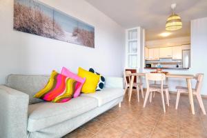 a living room with a couch and a table at Apartamento El Charcon A - 10 meters to the Beach By Lanzarote Vacation Homes in Arrieta