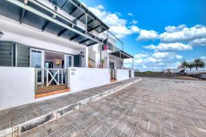 a house on the beach with a driveway at Apartamento El Charcon A - 10 meters to the Beach By Lanzarote Vacation Homes in Arrieta