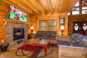 un salon avec une cheminée et une télévision dans l'établissement Poolhouse Lodge by American Patriot Getaways, à Waldens Creek