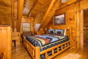 une chambre avec un lit dans une cabane en rondins dans l'établissement Poolhouse Lodge by American Patriot Getaways, à Waldens Creek