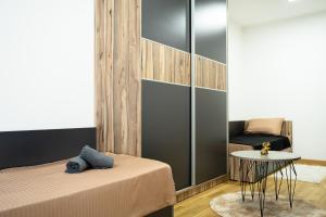 a bedroom with a bed and a table and a chair at Comfort Apartment Skopje in Skopje