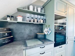 a kitchen with white cabinets and a counter top at Exklusives Heidehaus in Garlstorf mit Musikzimmer in Garlstorf