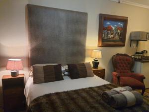 una camera da letto con un letto e una sedia rossa di Gemsbok Cottage a Bethlehem