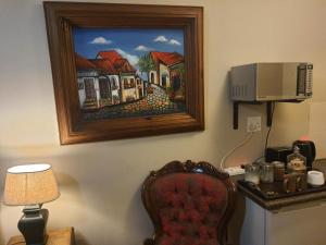 a room with a painting on the wall and a chair at Gemsbok Cottage in Bethlehem