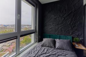 Oceanview Apartment baltyk Gdynia -Bezpłatny parking في غدينيا: غرفة نوم بها سرير ونافذتين