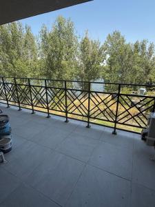 einen Balkon mit Blick auf den Fluss und die Bäume in der Unterkunft RIVERSIDE Kozloduy in Kozloduy