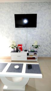a room with a white desk with a tv on the wall at Lux trosoban in Sremska Mitrovica