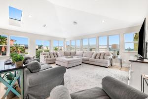 Una gran sala de estar con sofás y un televisor. en Sea Gem Beach Slp 16 Amenities, en St. Augustine
