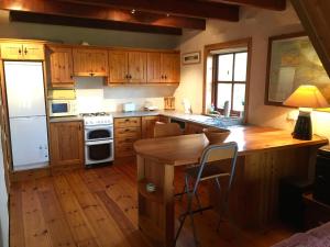a kitchen with wooden cabinets and a wooden table at Cedar Boathouse Overlookng Baltimore, West Cork & Islands in Baltimore