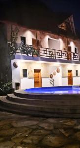 une maison avec piscine la nuit dans l'établissement Bush Paradise Kiwengwa, à Kiwengwa