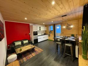 a living room with a couch and a table and a kitchen at Le Fournil du Couvent in Les Rousses
