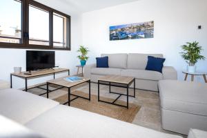 a living room with a white couch and tables at Résidence Le Jardin d'Eugénie in Sanary-sur-Mer