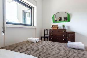 Un dormitorio con una cama, una cómoda y un espejo. en KOPKE 113, local & spacious 2Bed, en Oporto