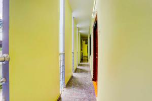an empty hallway with yellow walls and a red door at Hotel O Tirupati Railway Junction Y Stay Home Stay in Tirupati
