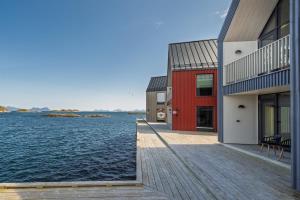 a house on the water with a dock at Rorbuleilighet Lysøya 1H in Henningsvær