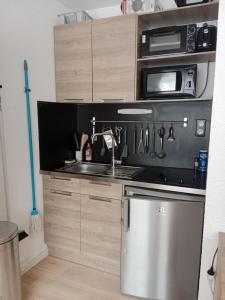 une cuisine avec une cuisinière et un micro-ondes dans l'établissement Les Ours Bruns, à Aragnouet