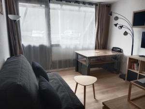 a living room with a couch and a desk at Les Ours Bruns in Aragnouet