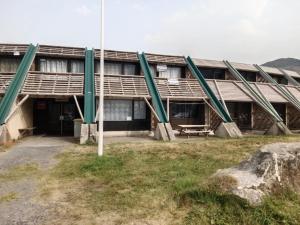an old building with green poles in front of it at Les Ours Bruns in Aragnouet