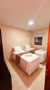 a room with two beds and a window at Flat Residencial dos Anjos in Maceió