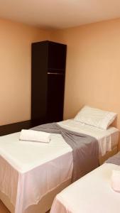 a room with two beds with white sheets at Flat Residencial dos Anjos in Maceió +12 photos