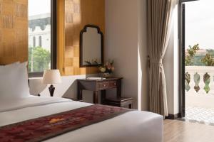 a bedroom with a bed and a mirror and a window at Tam Coc Babylon Hotel in Ninh Binh +36 photos