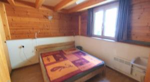 a bedroom with a bed in a room with a window at Wallisblick in Blatten bei Naters
