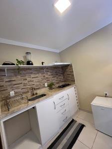 a kitchen with a sink and a counter at Lofts Serena - No Centro de Itacaré, a passos da Pituba in Itacaré