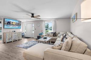 a living room with a couch and a tv at Endless Fun & Coastal Comfort with Game Room, Bikes & Beach Vibes - Luanne Beach Retreat - Roelens in Fort Myers