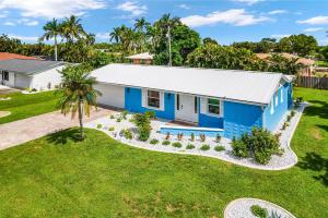 an aerial view of a blue house with a yard at Endless Fun & Coastal Comfort with Game Room, Bikes & Beach Vibes - Luanne Beach Retreat - Roelens in Fort Myers