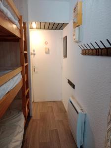 Cette chambre dispose d'un couloir avec des lits superposés et une porte. dans l'établissement Les Ours Bruns, à Aragnouet