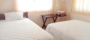 a bedroom with a bed and a table and a window at Casa El Guayacan in Baños +14 photos