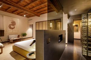 a bedroom with a bed and a room with a couch at Daplace - Palazzo Serpe Suites near Colosseum in Rome