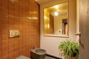 a bathroom with a sink and a mirror at Daplace - Palazzo Serpe Suites near Colosseum in Rome +30 photos