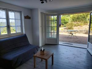 a living room with a couch and a table at Le Rin de la fôret in Chambon-sur-Cisse